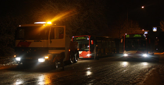 Der Abschleppwagen steht vor einem anderen Bus, während noch einer daran vorbeifährt
