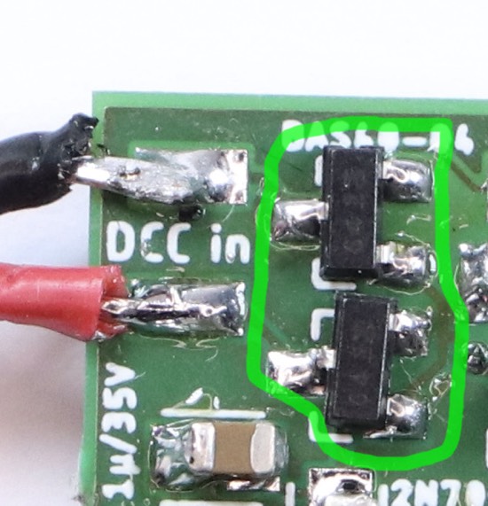 Excerpt from the photograph of the circuit board. Two identical parts with three pins each are highlighted.