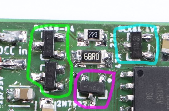 Excerpt from the photograph of the circuit board. Highlighted are four different components that all look alike and all have three pins each.